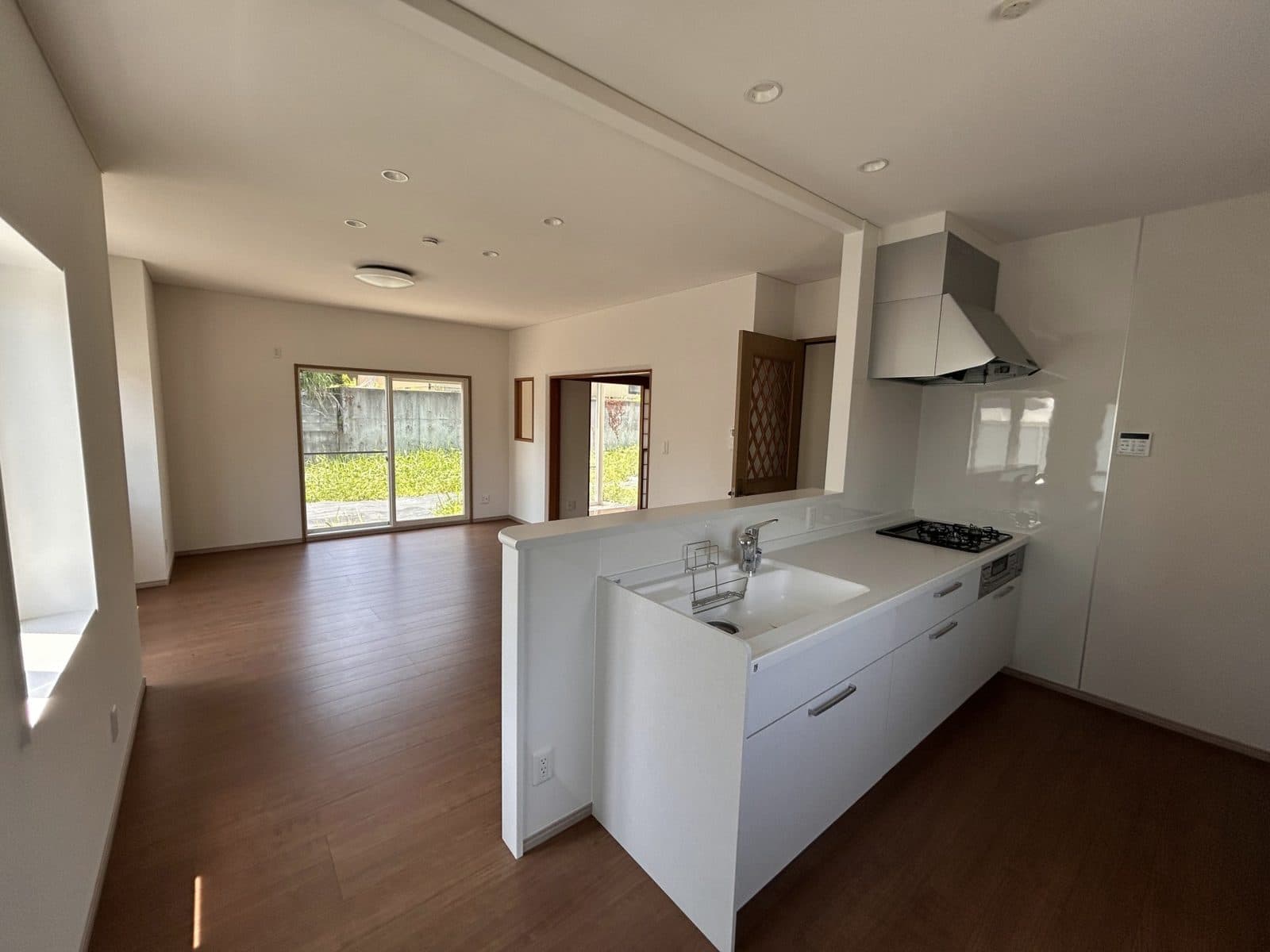 Inside the renovated Iizuna home: new flooring and a new white kitchen open to the living room